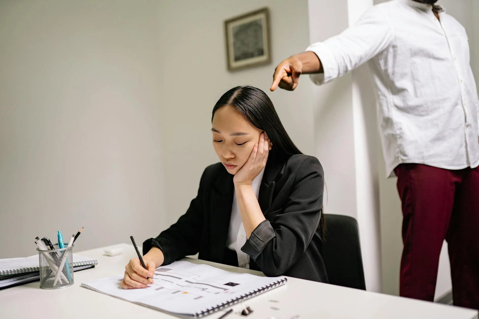 An unhappy employee experiencing workplace bullying, depicted by finger pointing in an office setting.