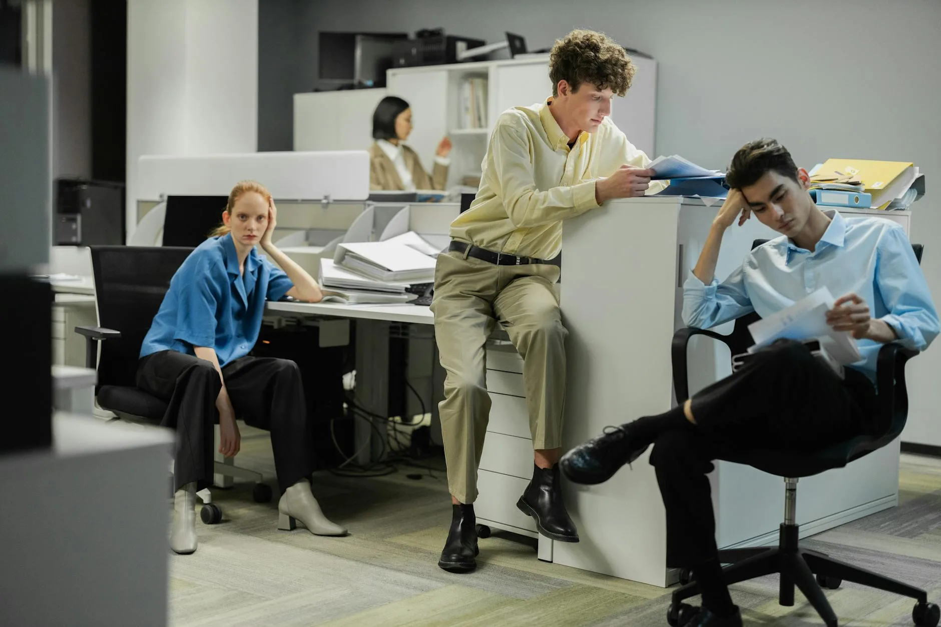 Team of professionals engaged in a pensive discussion in a modern office setting.