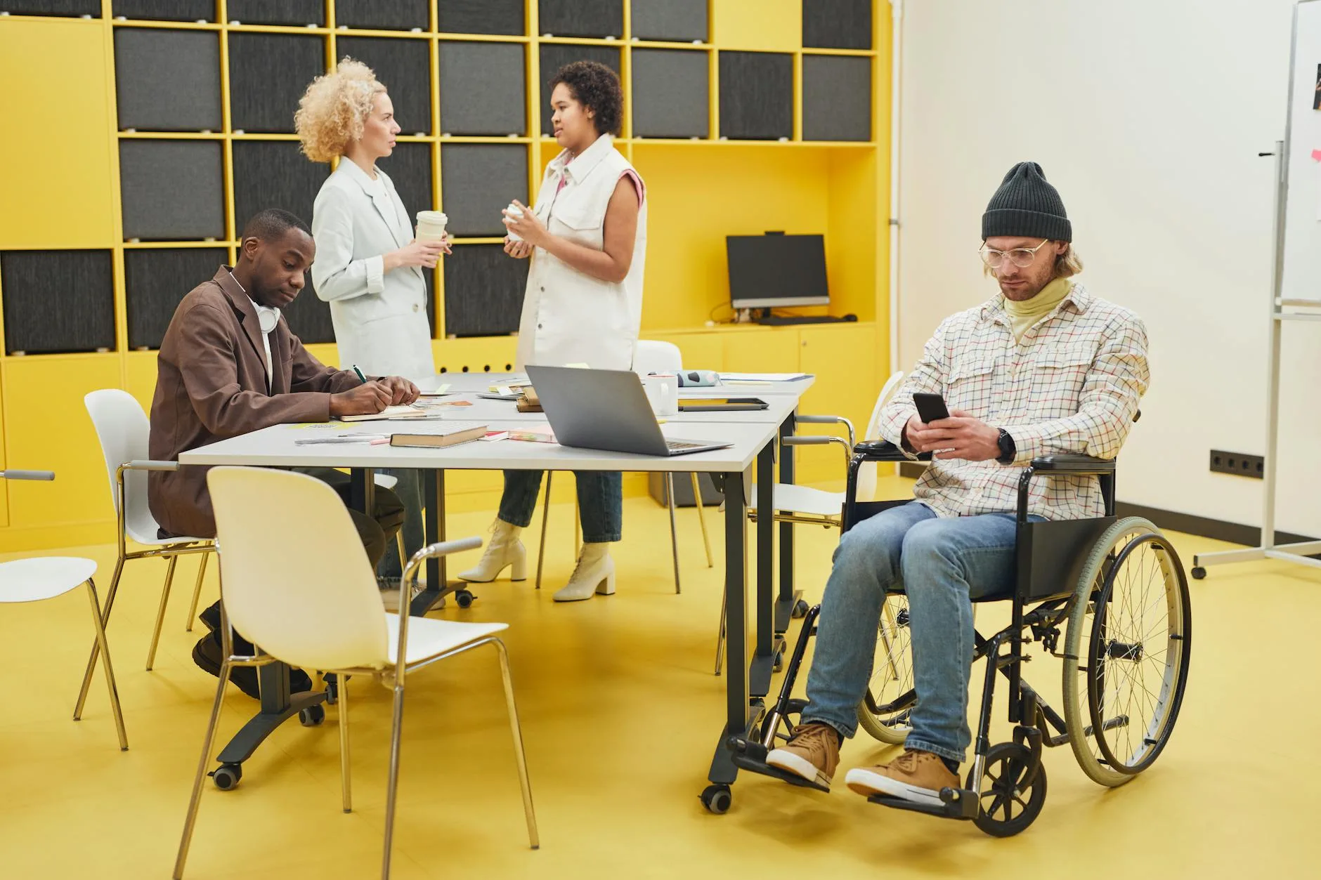A diverse office team collaborating indoors, showcasing teamwork and inclusivity.