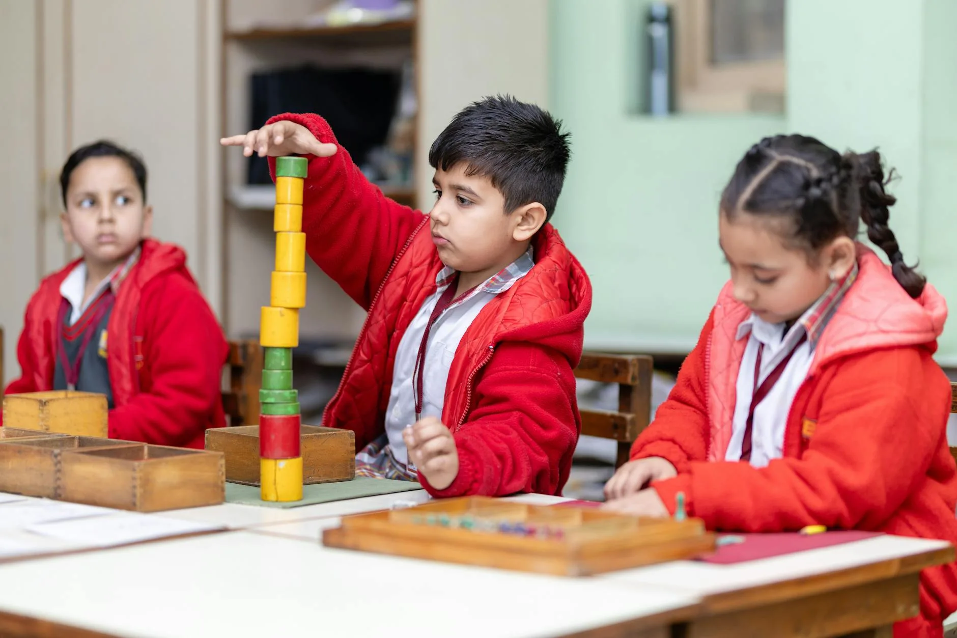 Children learning with Montessori materials in a classroom setting, fostering creativity and focus.