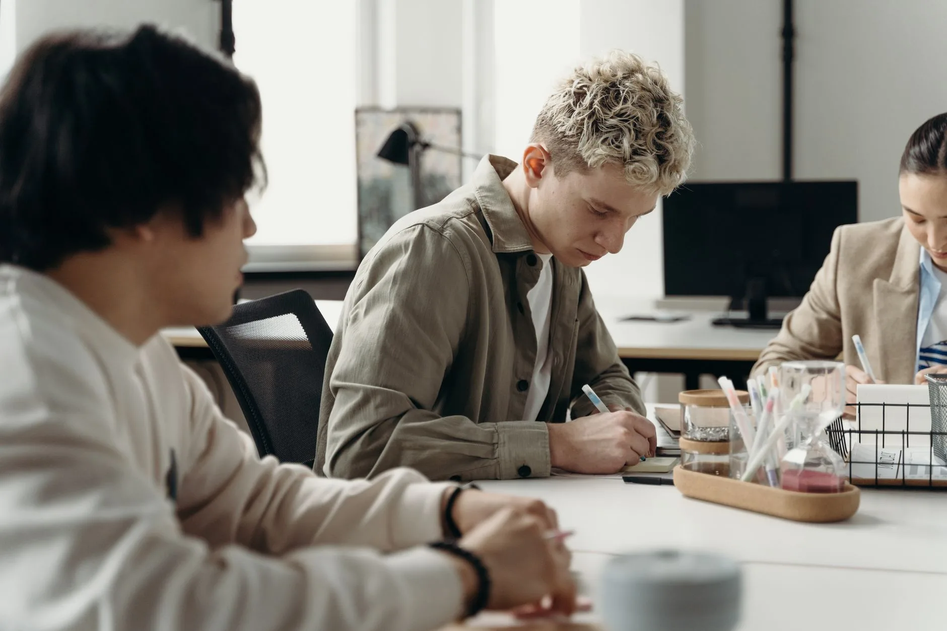 A diverse group of young professionals brainstorming in a contemporary office environment.